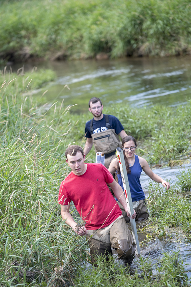 Penn State Natural Resource Engineering students crossing a river