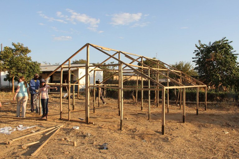 The sun begins to set as the greenhouse structure is completed in Zimba