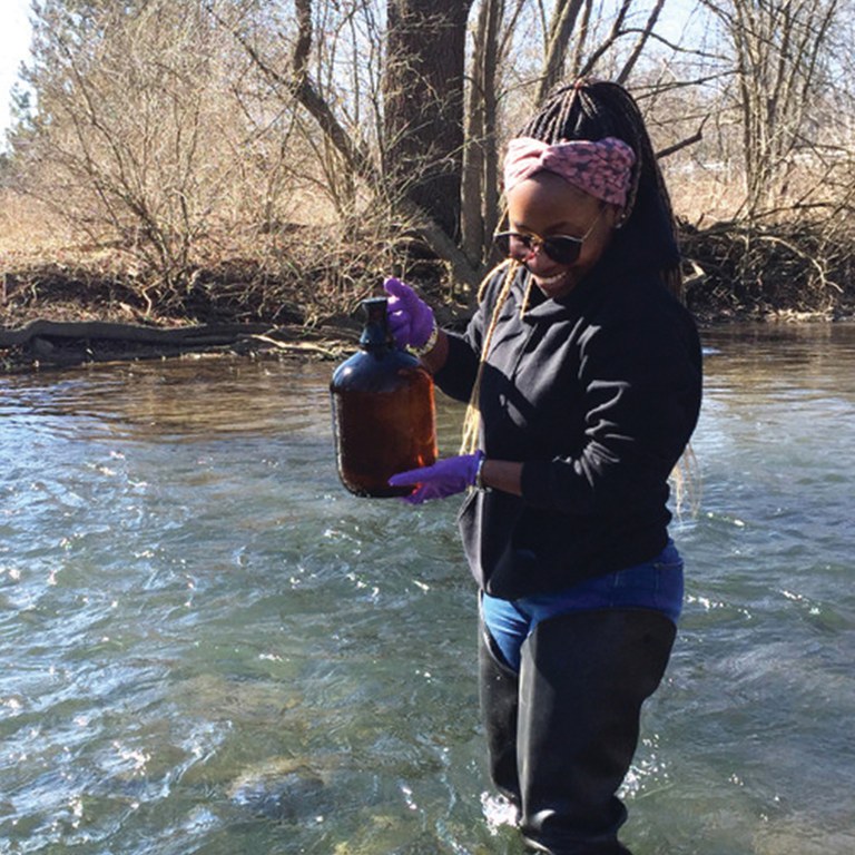 Lead researcher and doctoral student Marlene Ndoun samples water in central Pennsylvania's Spring Creek for emerging contaminants. Photo: Penn State