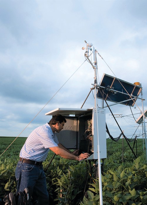 Researcher Suat Irmak programming the datalogger in one of his surface water vapor and energy flux towers to measure crop water use, all incoming and outgoing radiation fluxes, and all other climate variables such as air temperature, relative humidity, vapor pressure deficit, net radiation, precipitation, soil moisture, soil temperature on an hourly basis. Credit: Suat Irmak