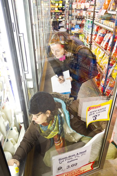 two women recording contents of grocery freezer